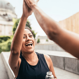 A smiling couple high-five post exercise
