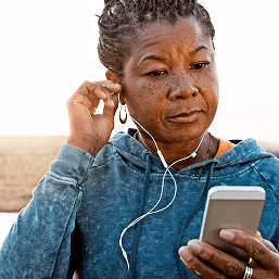 A middle-aged woman in sportswear looking at a mobile phone
