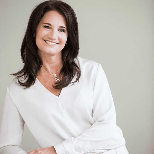 A headshot of Jen Elmquist in neat white attire.